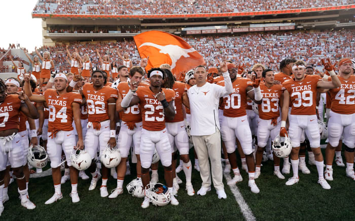 Texas football team salutes fans at end of game.